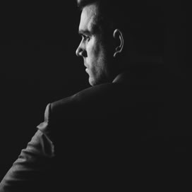 Sophisticated black and white studio portrait of an elegant businessman in a suit.
